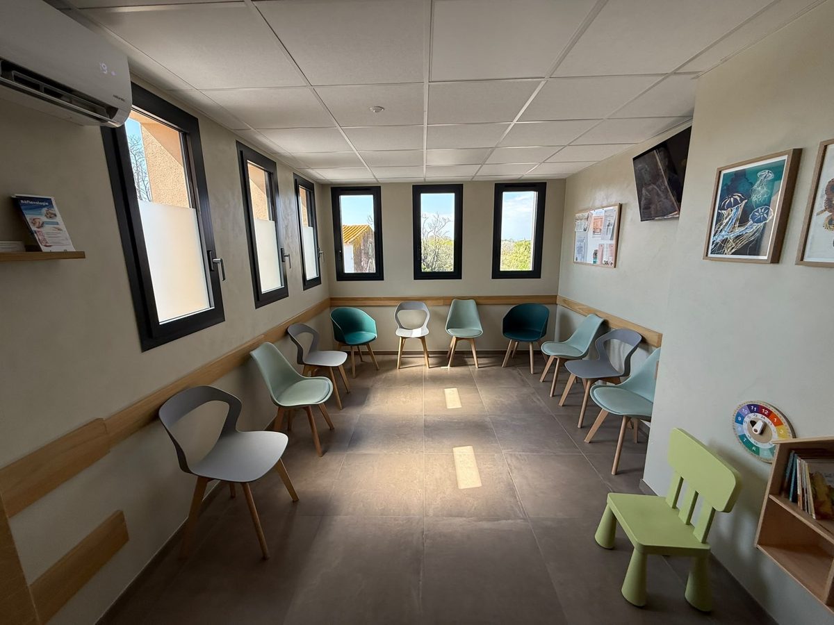 Salle d’attente lumineuse avec chaises et coin enfants